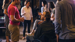 Man in wheelchair at an accessible event talking to colleagues