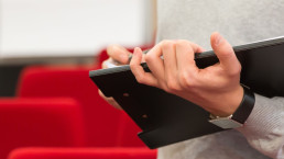 Holding a clipboard at an academic conference