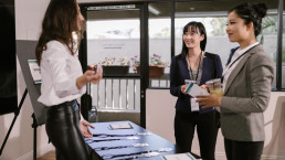 Three women research networking at an academic conference